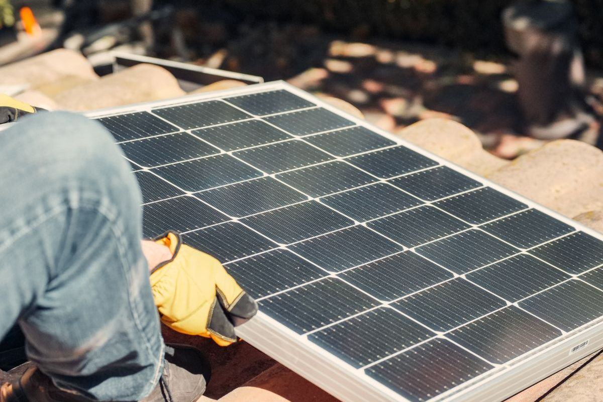 Solar panel being positioned on a tiled roof