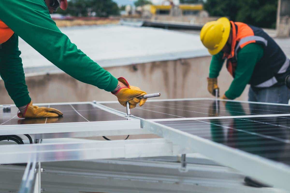 Two installers fixing solar panels to mounting rails